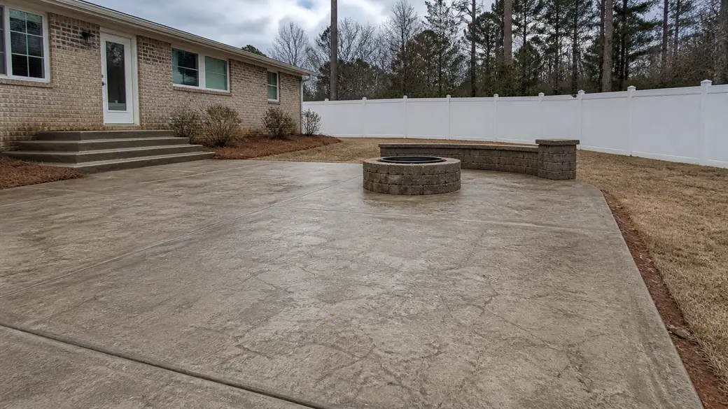 concrete patio construction completed by a local contractor at a buff-brick ranch home in Warner Robins, GA, after a rain shower.